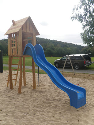 Spielturm aus Robinie und Lärche mit blauer Rutsche für öffentliche Plätze