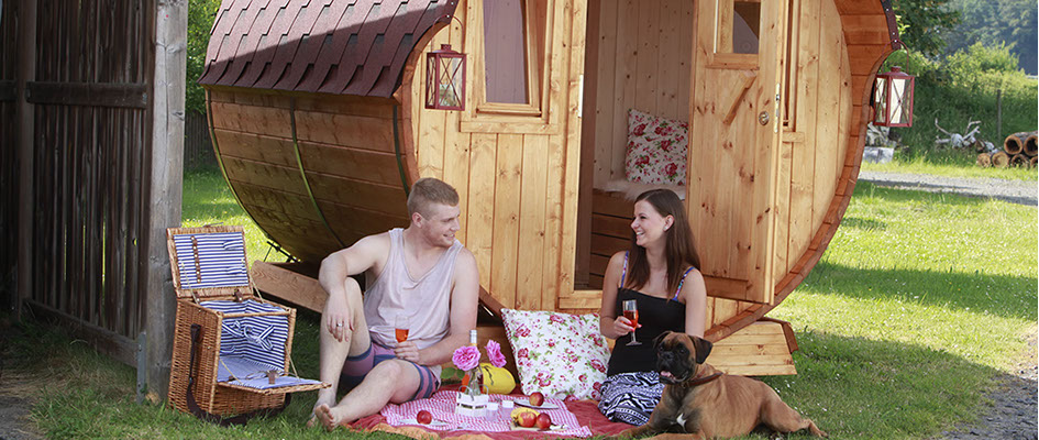 Junges Paar sitzt fröhlich einem  Campingfass