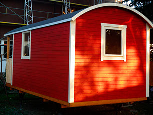 Schöner roter Holzbauwagen bei stimmungsvollem Sonnenlicht