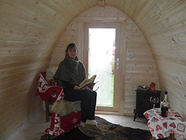 Frau sitzt entspannt im Hobbit Home und liest ein Buch