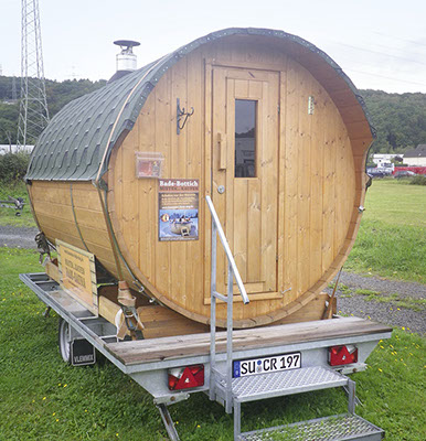 Junges Paar sitzt fröhlich einem  Campingfass